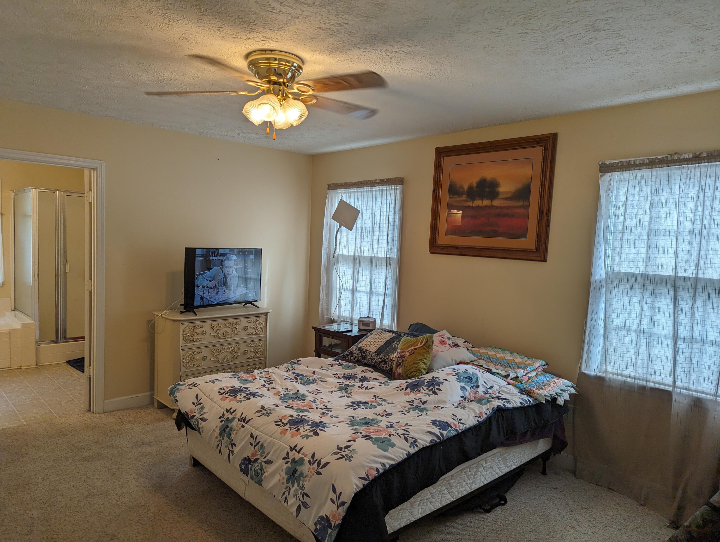 4715 Providence Church Road Ferrum, VA 24088 - Photo 16 of 46 a bedroom with a bed and a chandelier