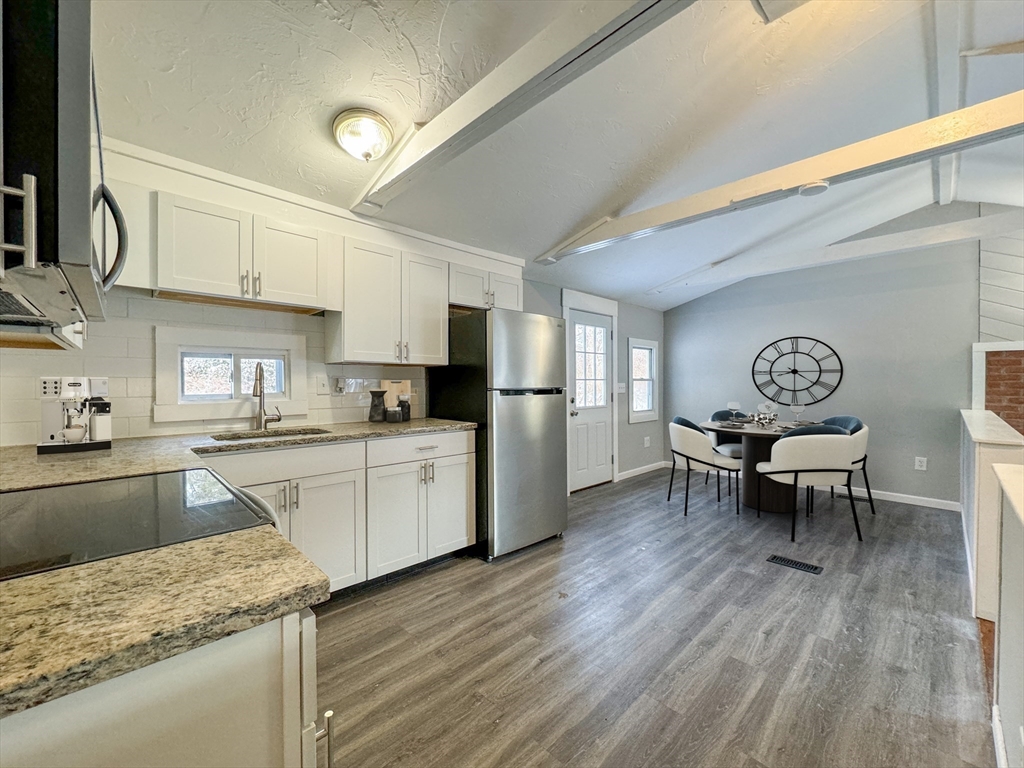 16 Schoolhouse Cross Road Brookfield, MA 01506 - Photo 5 of 39 a kitchen with granite countertop refrigerator sink dining table and chairs
