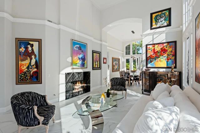 a view of a dining room with furniture a chandelier and a window