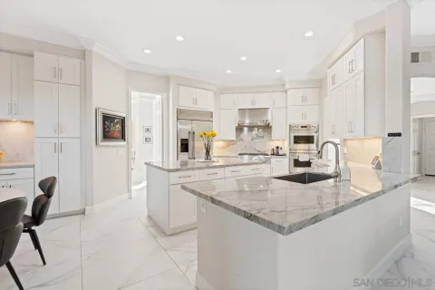 a living room with furniture kitchen view and a flat screen tv