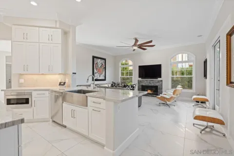 a living room with stainless steel appliances kitchen island granite countertop furniture and a large window