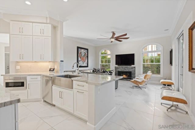 a living room with stainless steel appliances kitchen island granite countertop furniture and a large window