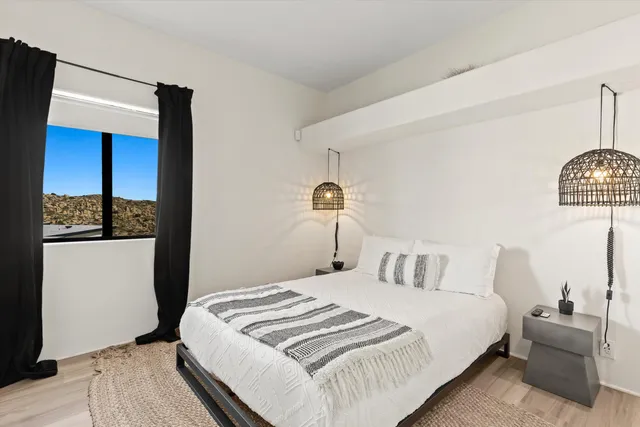 a bedroom with a bed and wooden floor