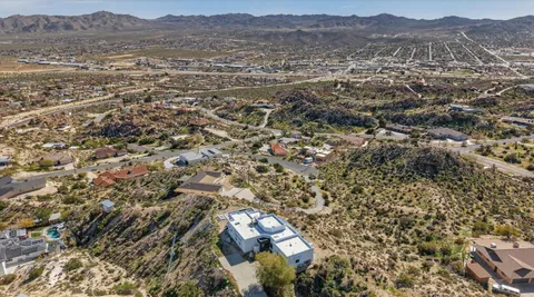 an aerial view of house with yard and mountain view in back