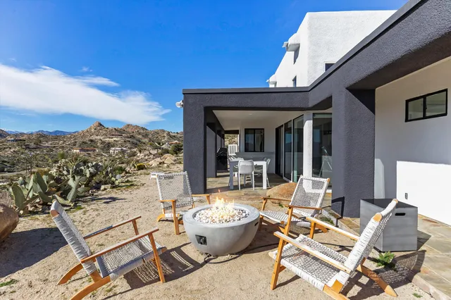 a view of a patio with couches table and chairs and potted plants
