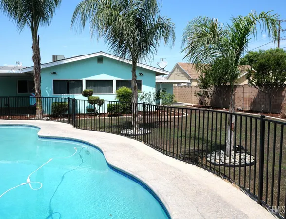 a view of a house with backyard and swimming pool