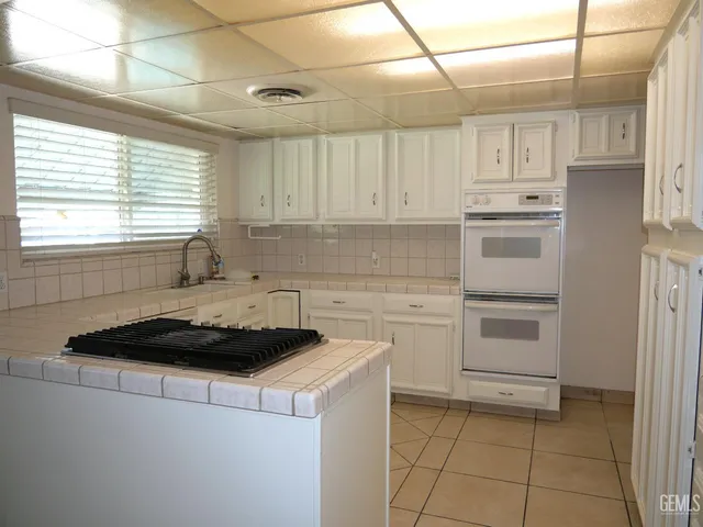a kitchen with a stove a sink and cabinets