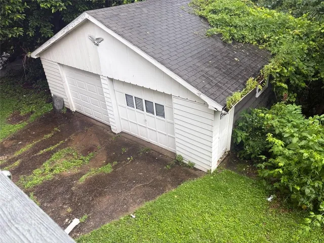 a view of a white house next to a yard