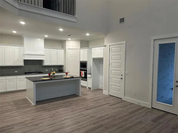 a kitchen with stainless steel appliances a stove and wooden floor
