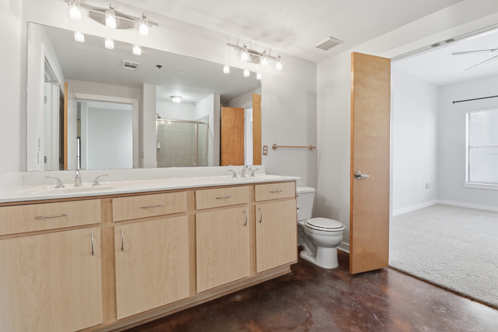 1803 Broadway, Unit 519 Nashville, TN 37203 - Photo 15 of 31 a spacious bathroom with a double vanity sink a large mirror and a toilet