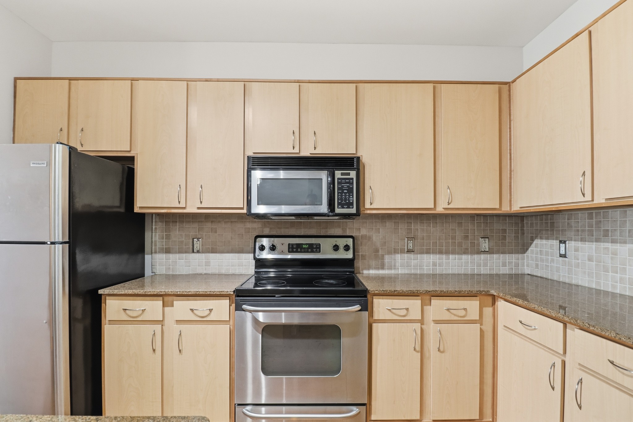 1803 Broadway, Unit 519 Nashville, TN 37203 - Photo 16 of 31 a kitchen with granite countertop white cabinets and stainless steel appliances