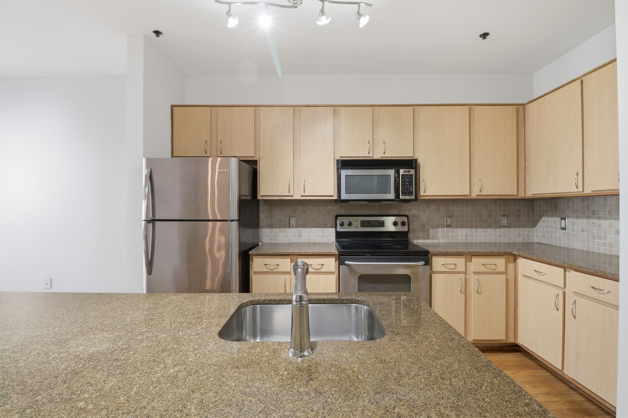 1803 Broadway, Unit 519 Nashville, TN 37203 - Photo 3 of 31 a kitchen with a sink a microwave a refrigerator and cabinets