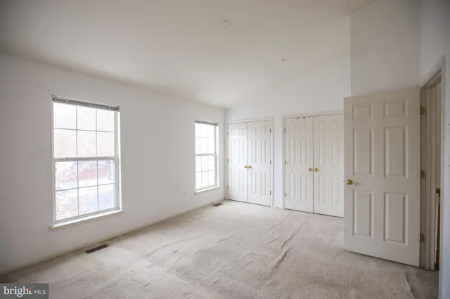 an empty room with windows and closet