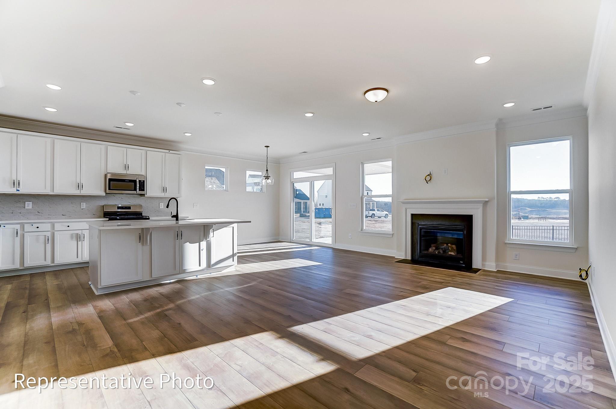 5009 Raging Crk Drive Indian Trail, NC 28079 - Photo 5 of 28 a open kitchen with granite countertop a stove top oven a sink white cabinets and wooden floor