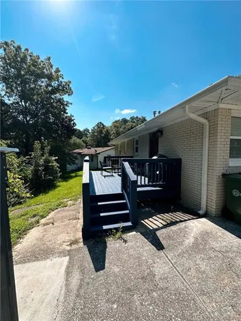 a bench sitting in front of a house with a yard