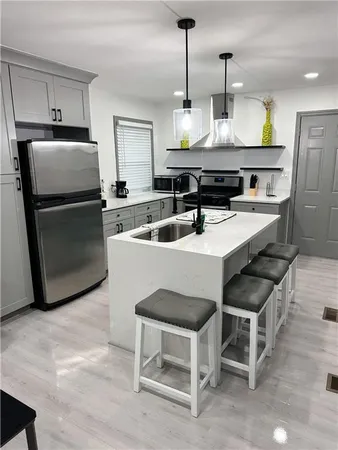 a kitchen with a sink a counter space and stainless steel appliances