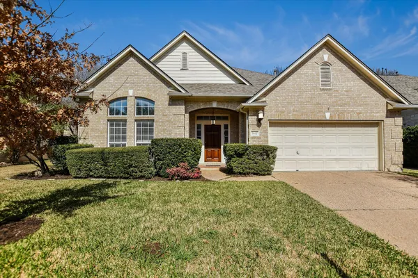 a front view of a house with a yard and garage