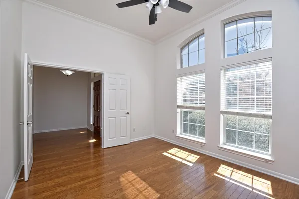 a view of an empty room with a window and wooden floor