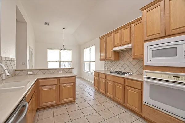 a kitchen with a stove sink and cabinets