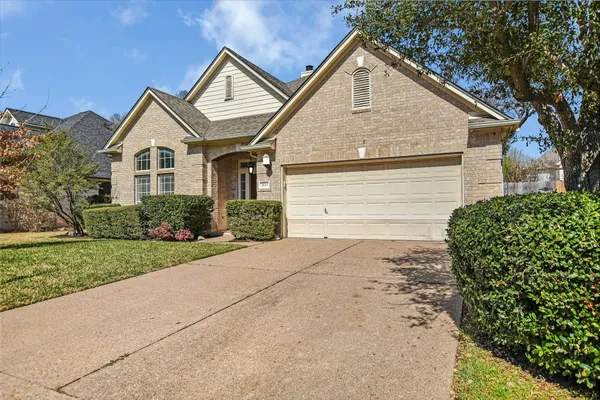 a view of a house with a yard and large tree