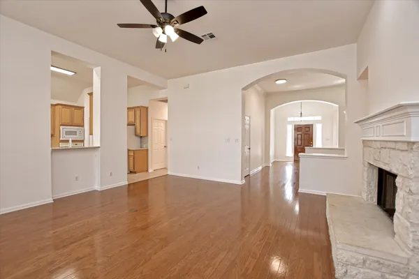 a view of empty room with wooden floor and fireplace