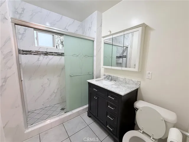 a bathroom with a granite countertop sink toilet and shower