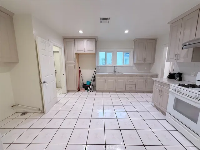 a kitchen with a sink a stove a refrigerator and cabinets
