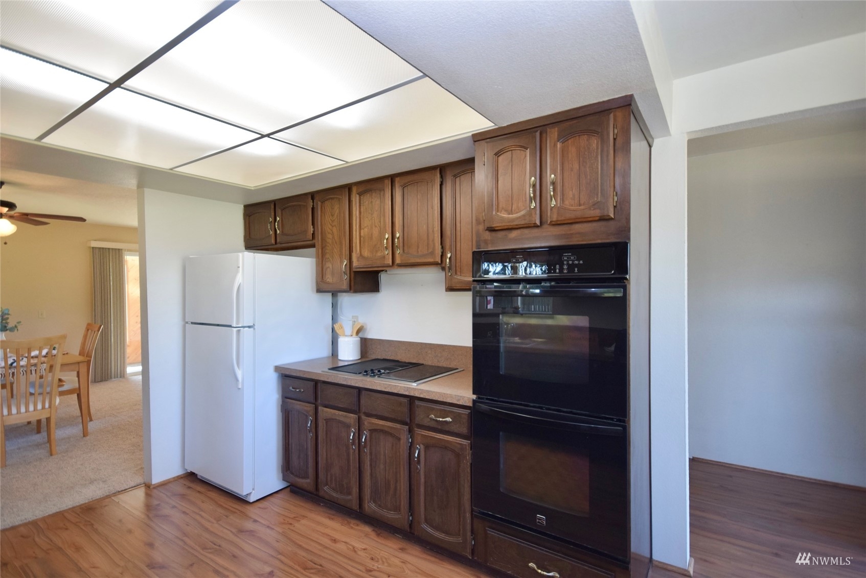 21 Clary Lane Sequim, WA 98382 - Photo 11 of 29 a kitchen with granite countertop wooden cabinets a refrigerator and a stove top oven