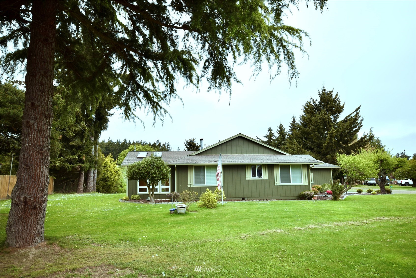 21 Clary Lane Sequim, WA 98382 - Photo 4 of 29 a front view of a house with a garden and trees