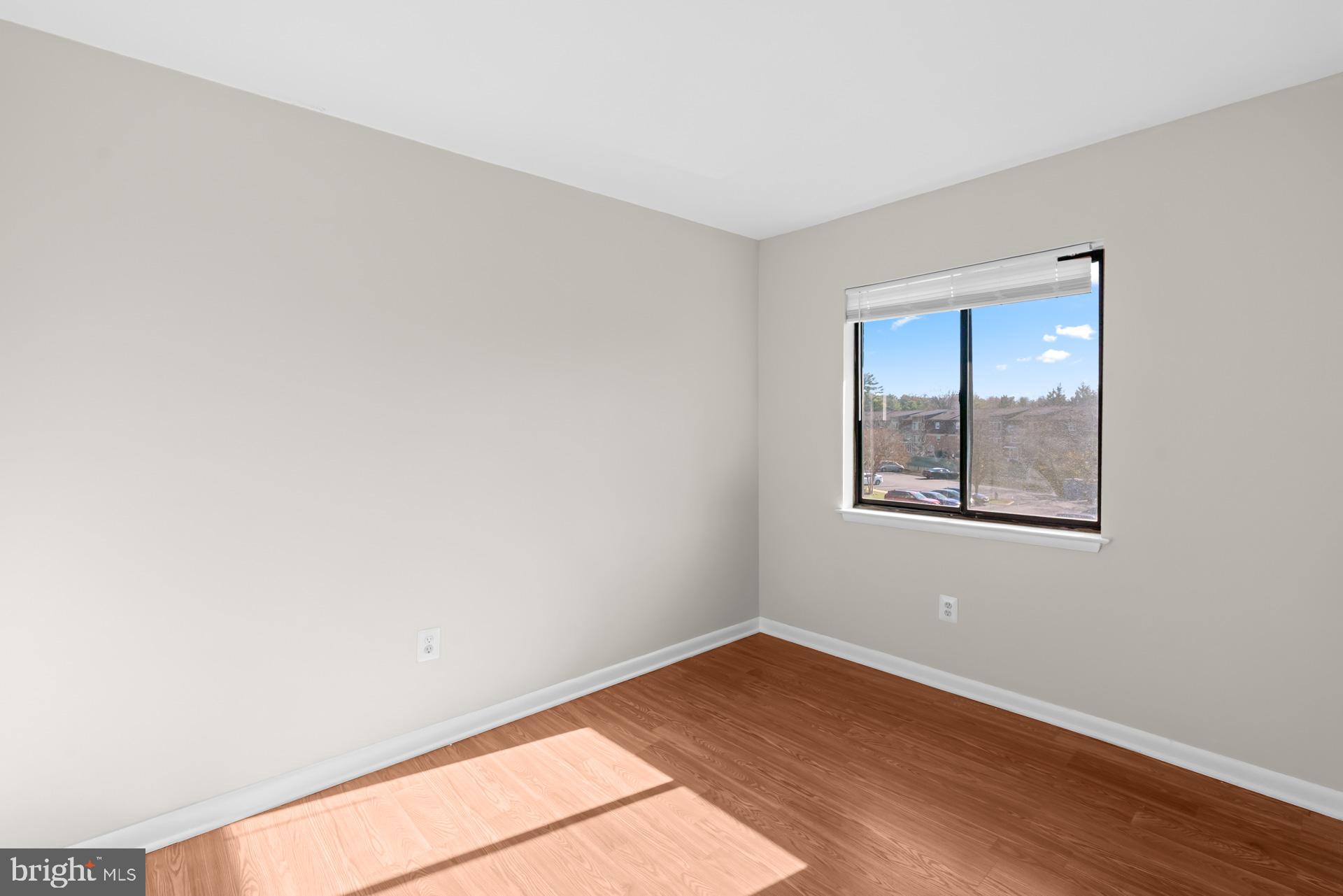 7616 Savannah Street, Unit 201 Falls Church, VA 22043 - Photo 12 of 29 a view of an empty room with wooden floor and a window