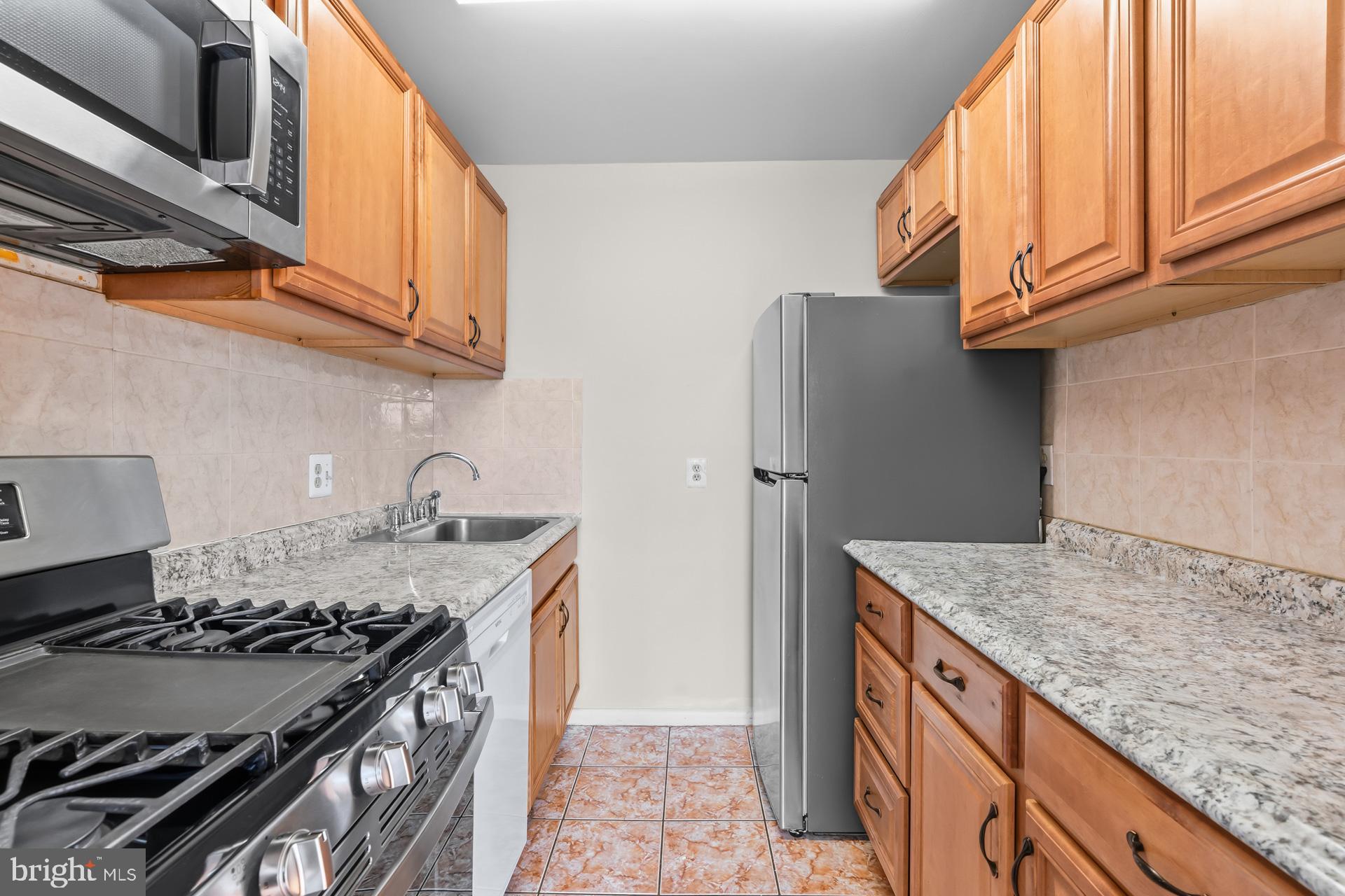 7616 Savannah Street, Unit 201 Falls Church, VA 22043 - Photo 5 of 29 a kitchen with stainless steel appliances granite countertop a sink stove and refrigerator