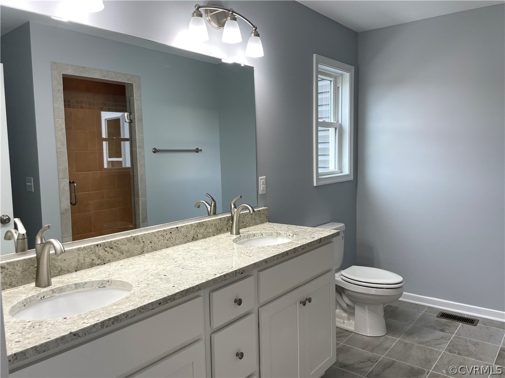 206 Wilson Road Blackstone, VA 23824 - Photo 20 of 38 a bathroom with a granite countertop toilet a sink and a mirror