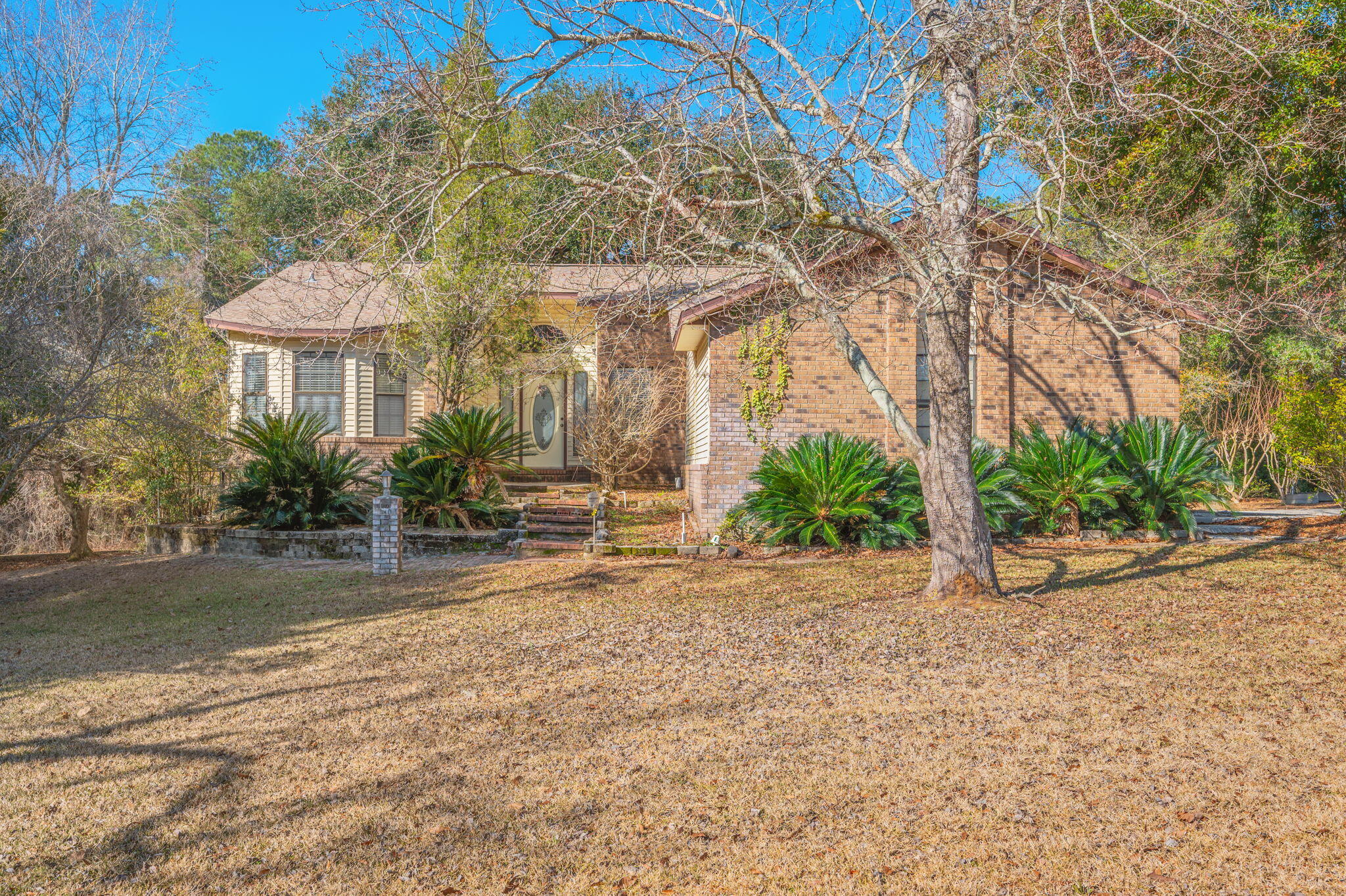 a view of a house with a yard and table and chairs under an umbrella