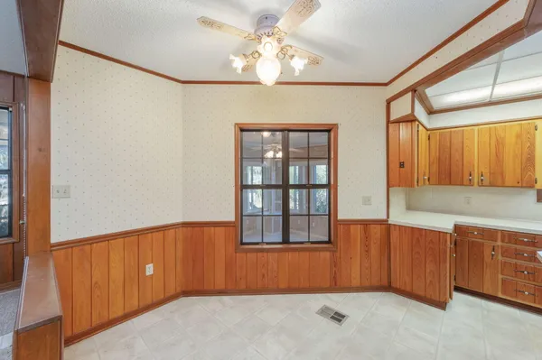 an empty room with a ceiling fan and window