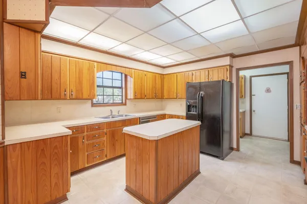 a kitchen with stainless steel appliances granite countertop a sink and a large window