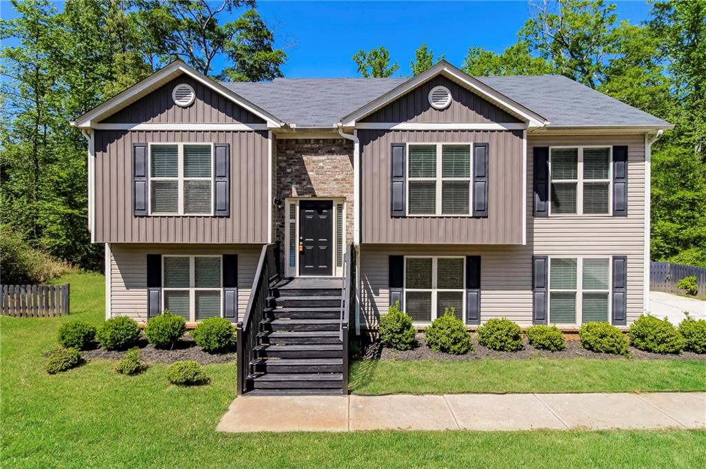 a front door view of a house with garden and trees