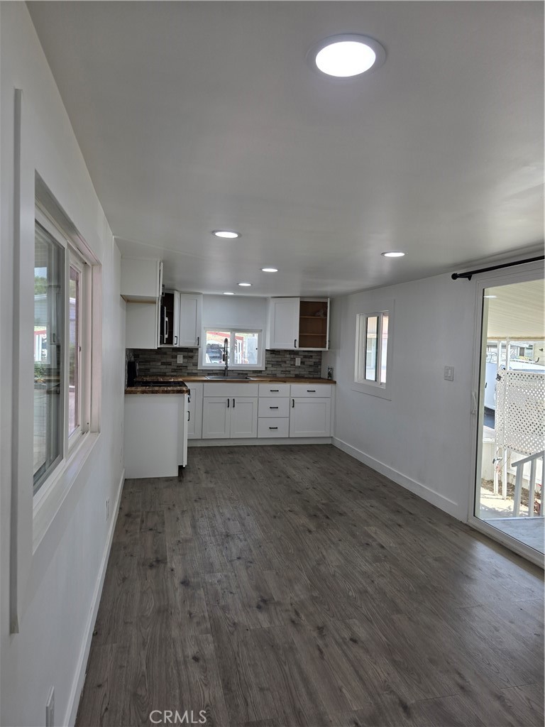 12401 Filmore Street, Unit 637 Sylmar, CA 91342 - Photo 3 of 14 a large kitchen with cabinets and wooden floor