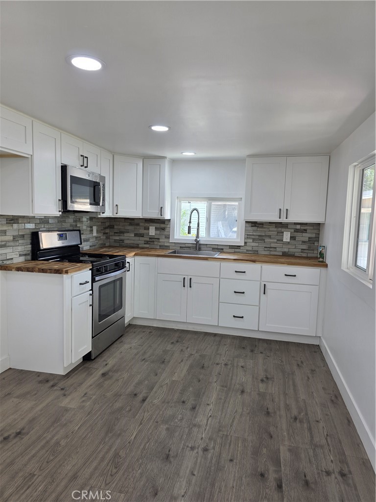 12401 Filmore Street, Unit 637 Sylmar, CA 91342 - Photo 4 of 14 a kitchen with granite countertop a stove top oven sink and cabinets