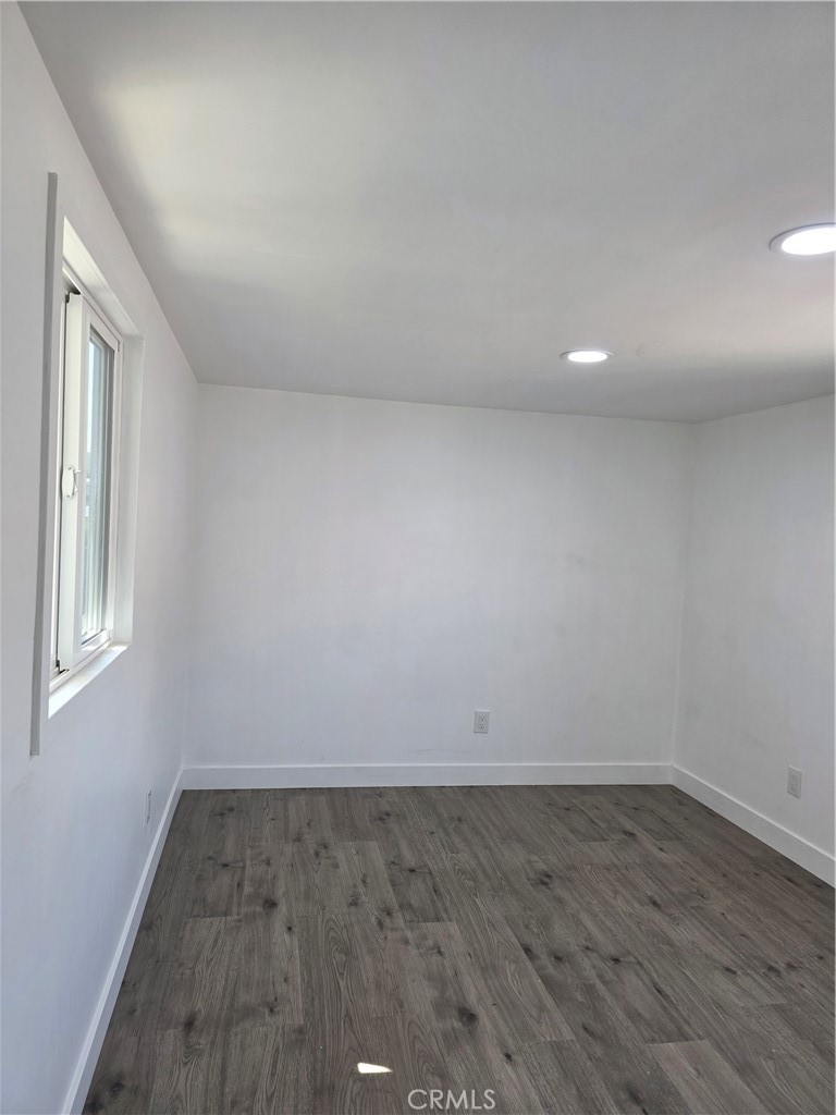 12401 Filmore Street, Unit 637 Sylmar, CA 91342 - Photo 5 of 14 an empty room with wooden floor and windows