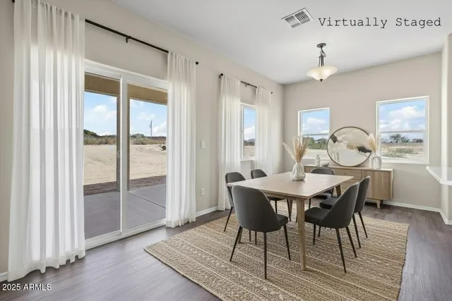an empty room with wooden floor a ceiling fan and windows
