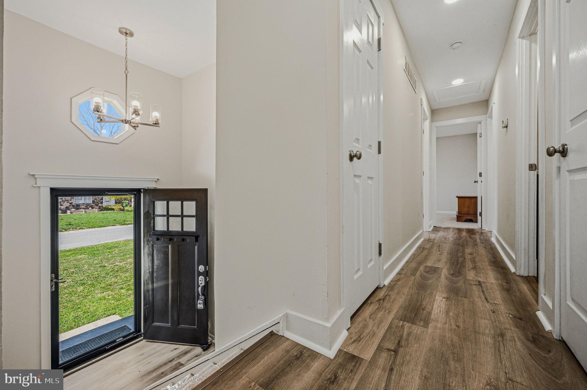 106 Fox Drive Newark, DE 19713 - Photo 21 of 37 a view of a hallway with wooden floor and a chandelier