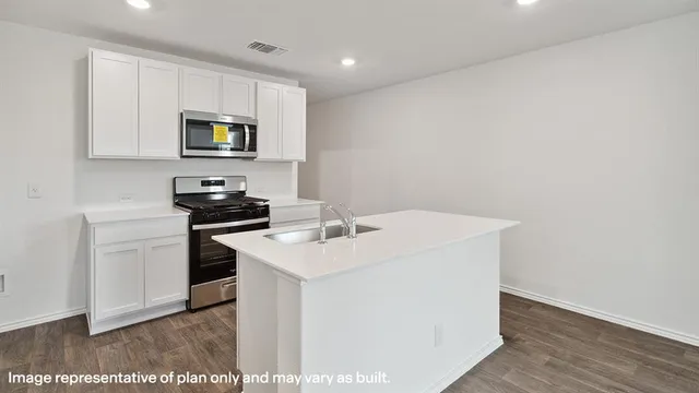 a kitchen with a sink a microwave and cabinets