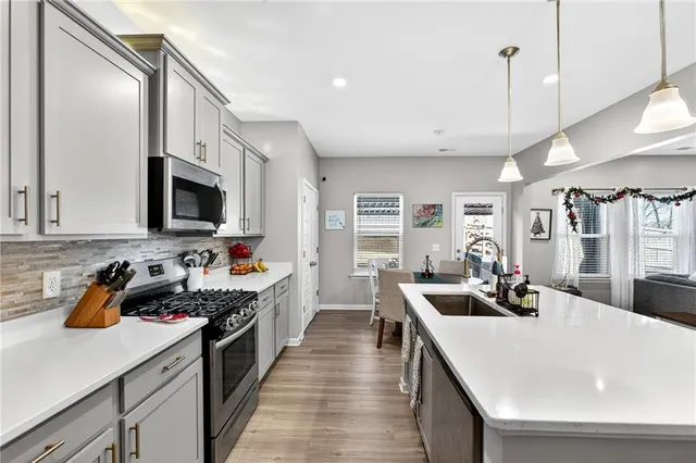 a kitchen with stainless steel appliances a stove sink microwave and cabinets