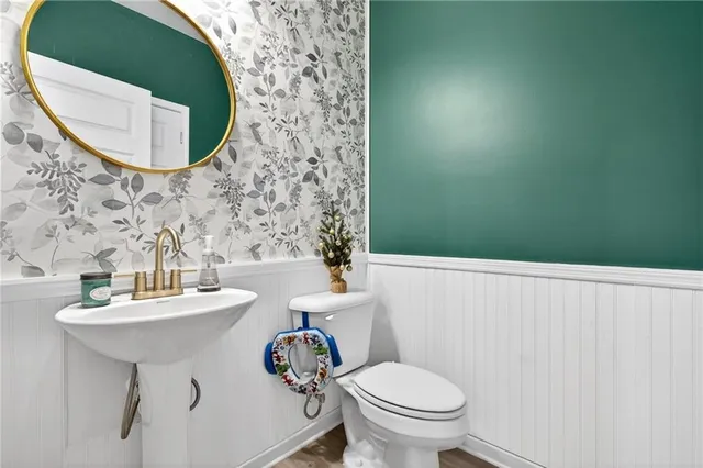a bathroom with a sink and mirror with toilet