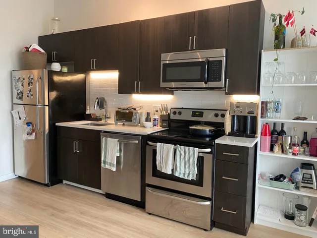 a kitchen with stainless steel appliances a stove a microwave and a refrigerator