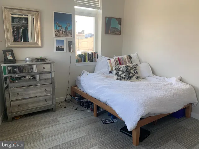 a bedroom with a bed and windows