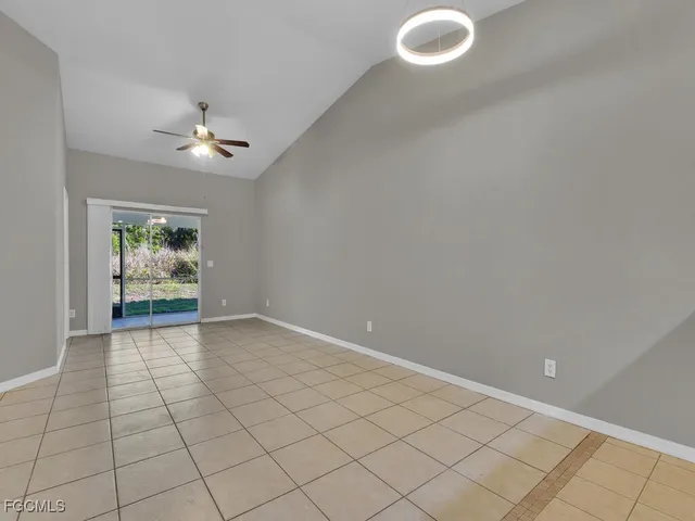 an empty room with windows and ceiling fan