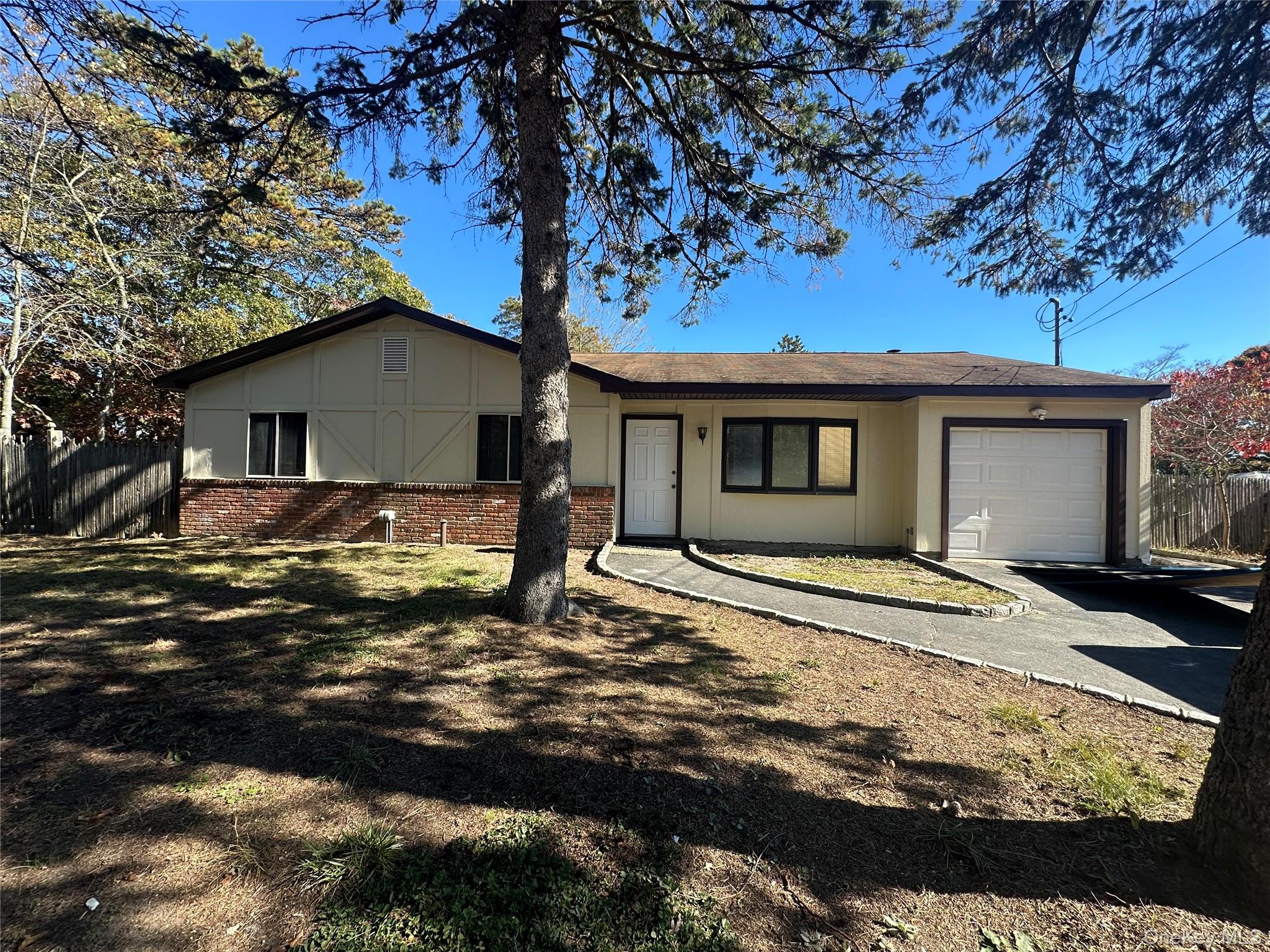 Ranch-style house featuring brick siding, an attached garage, and driveway