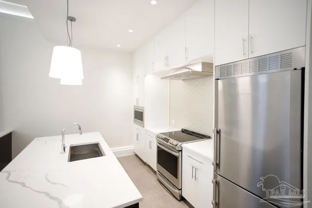 a kitchen with stainless steel appliances a stove a microwave and a refrigerator