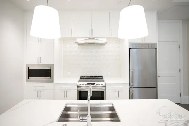 a kitchen with a table chairs sink and cabinets